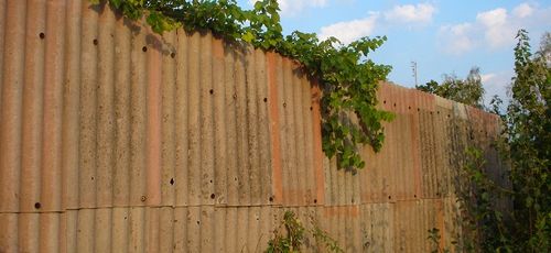 Высокий забор из материалов старого сарая