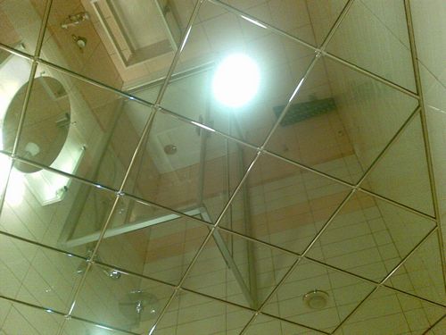 Стеклянный потолок: зеркальный в ванной и подвесной с подсветкой в спальне