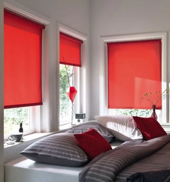 Интерьер спальни с красными рулонными шторами