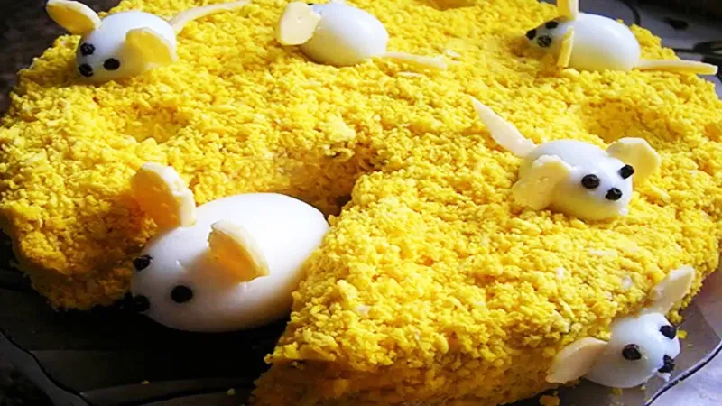 Выкладывайте мышек из яиц, когда салат уже готов. Для хвостов и ушек используйте маленькие кусочки сыра