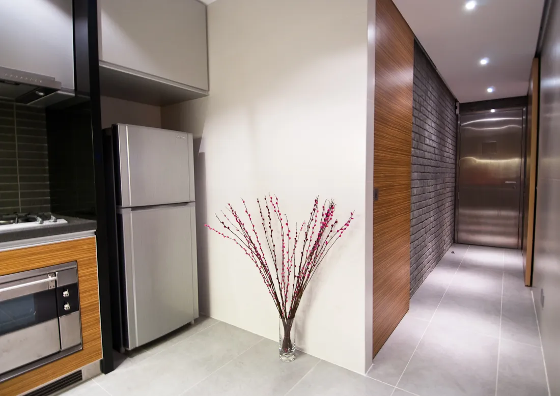 exterior-entrance-hall-with-a-kitchen-design-wall-decor-white-ceramic-gray-floor-fitted-wooden-wall-cabinets-lands-refrigerator-and-stove-oven-doors-and-wall-lights-flower-pots-beautiful-hallway-desig