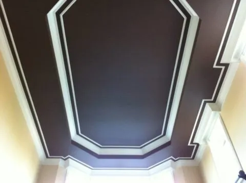 Контрастное оформление потолка при помощи черной краски и белых молдингов