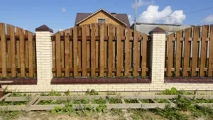 Готовый кирпичный забор с деревянными вставками смотрится очень респектабельно Готовый кирпичный забор с деревянными вставками смотрится очень респектабельно