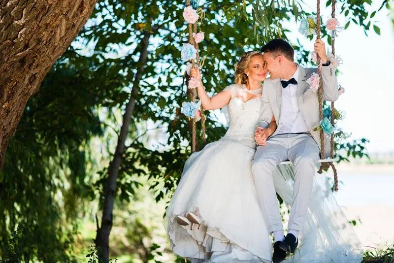 На качелях получаются яркие свадебные фотографии